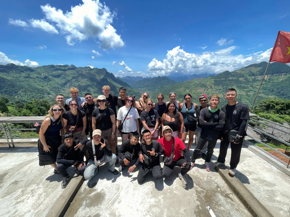 A group of people pose for a picture in the sunshine