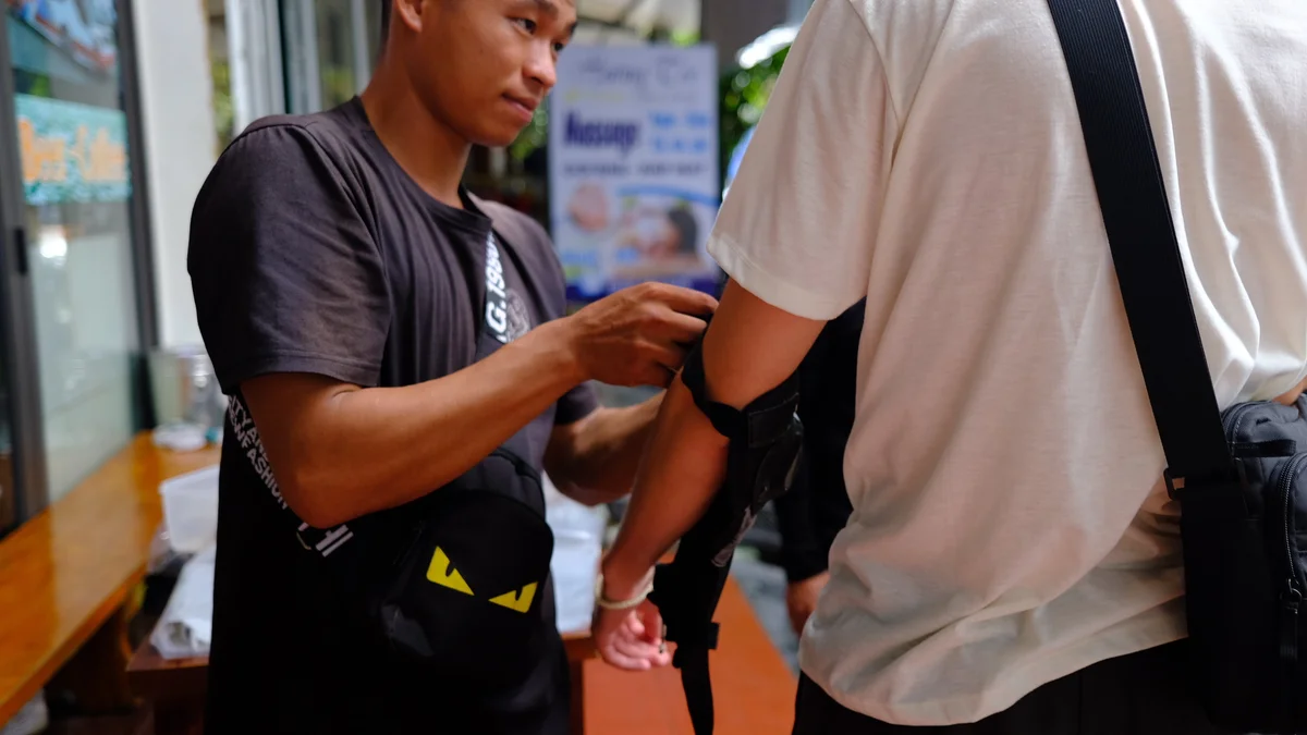 A bong hostel fixes a guests safety padding before the tour starts