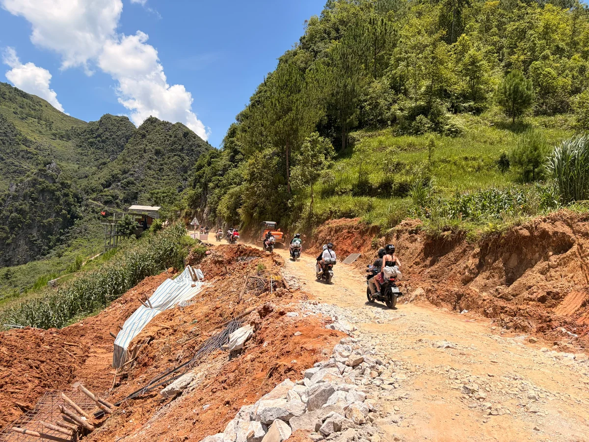 Roadway cleared with landfall on either side and mountains ahead
